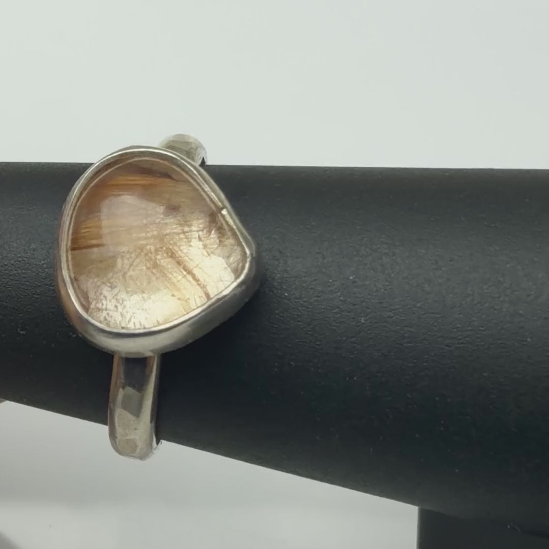 Rutilated quartz ring turning on a ring display