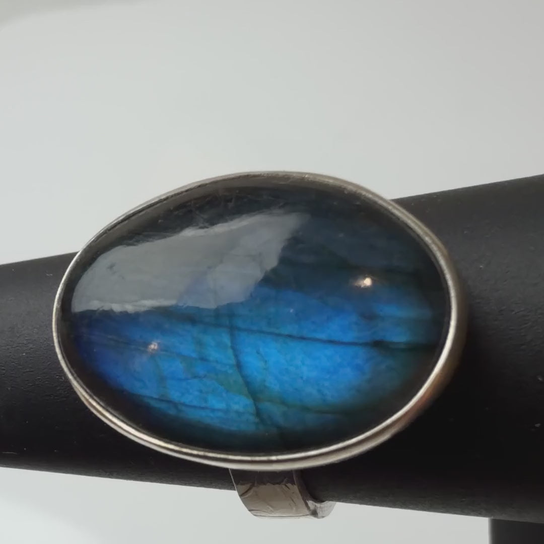 Labradorite ring in sterling silver turning on a black ring display